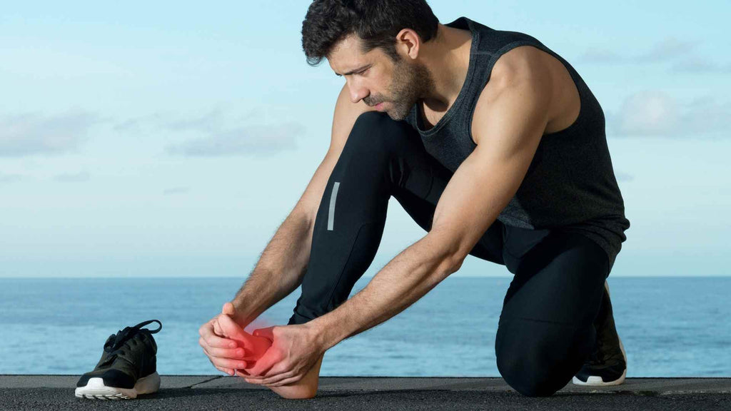 Man bending down to rub aching feet. Athlete's foot.