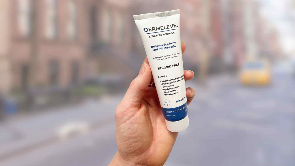 A person holding up a tube of Dermeleve® cream on a street.