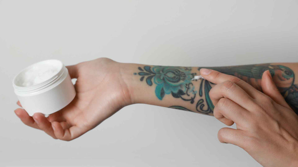 Person rubbing cream on tattoo