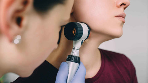 A woman being examined by a dermatologist