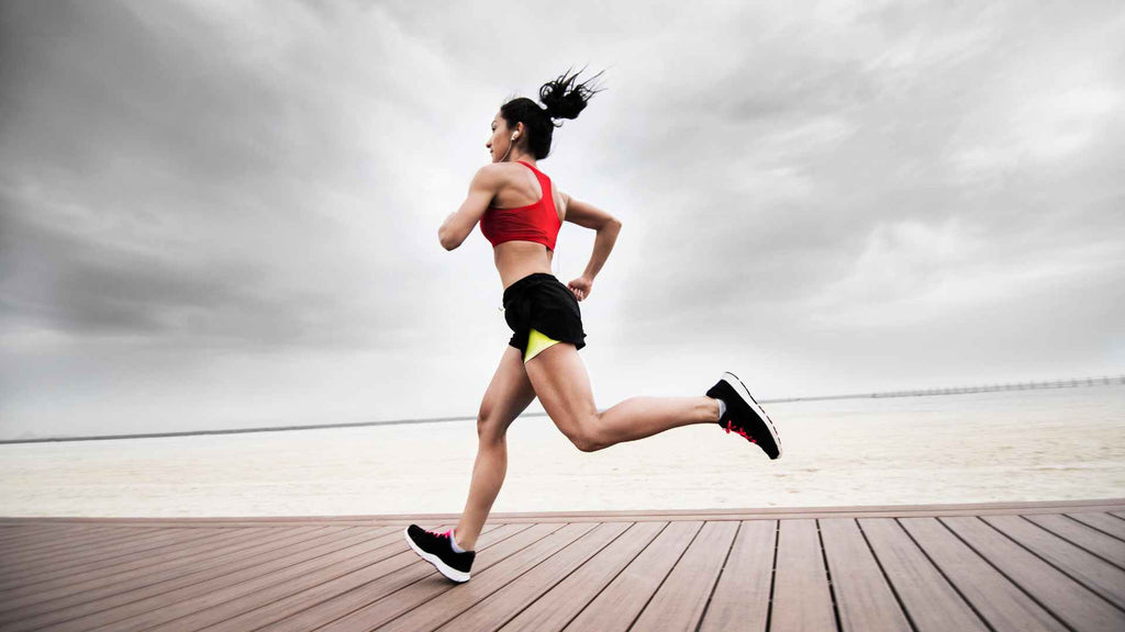 A woman jogging on a wooden boardwalk.