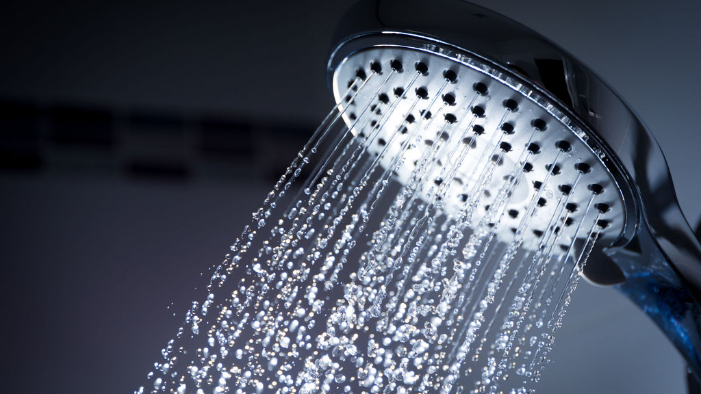 A close up of a shower head with water coming out of it.