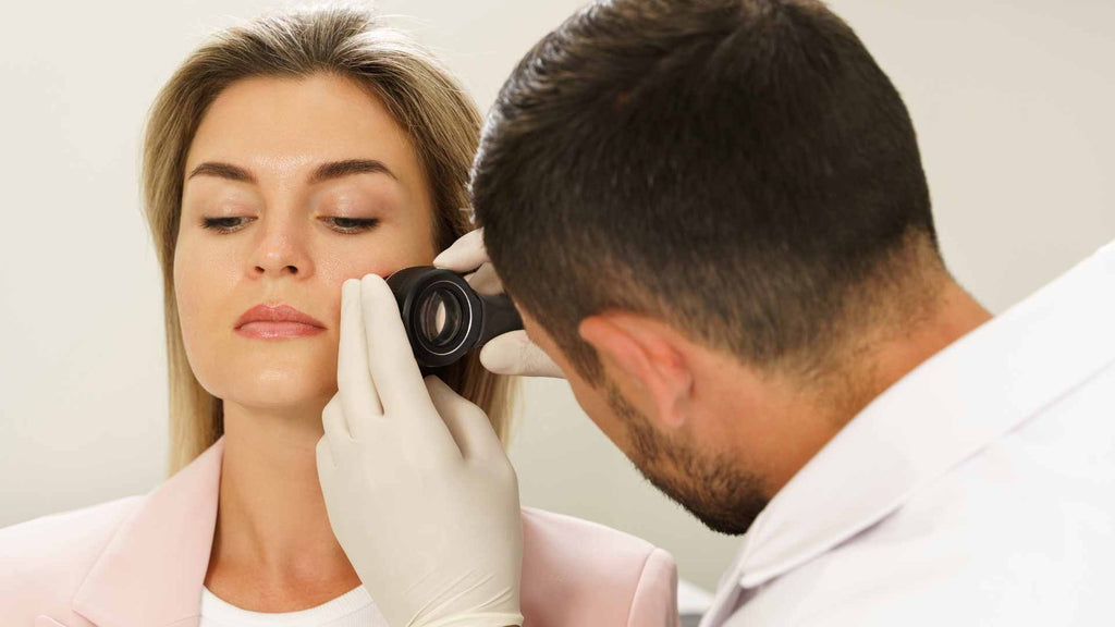 A dermatologist looking at a patient's face