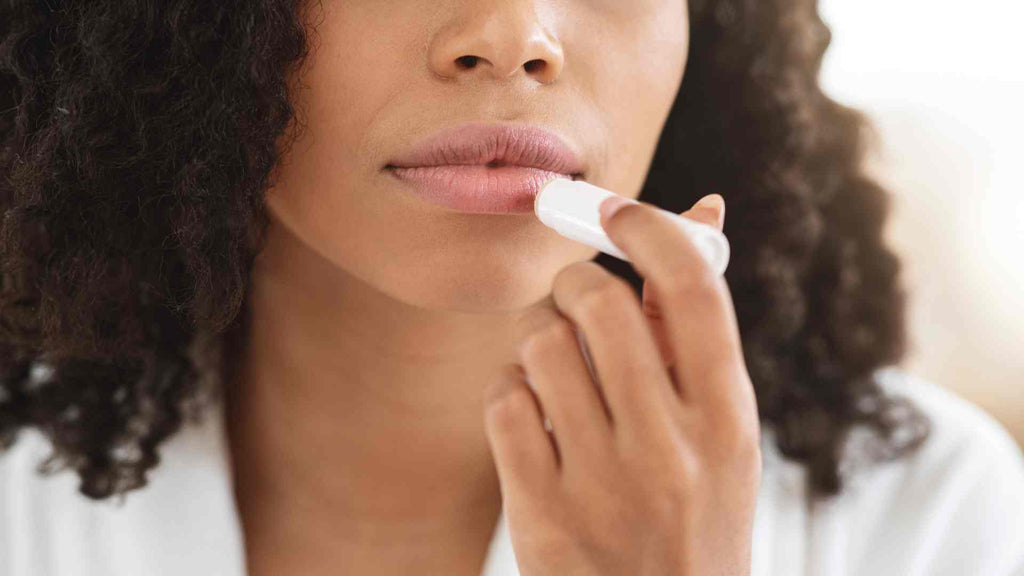 Woman putting on lip balm