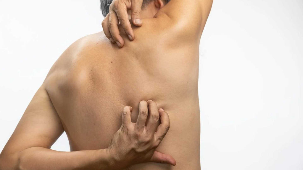 A man suffering from neuropathic itch scratches his back.