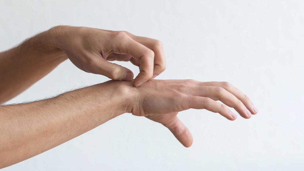 Man suffering from neuropathic itch scratches wrist, to no avail.