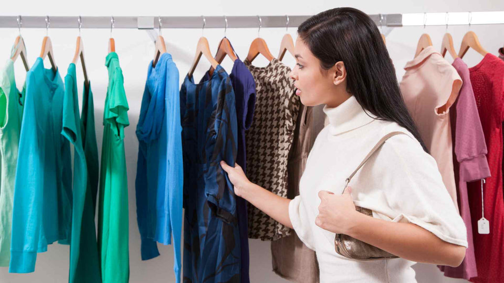 A woman looking at clothes on a rack.