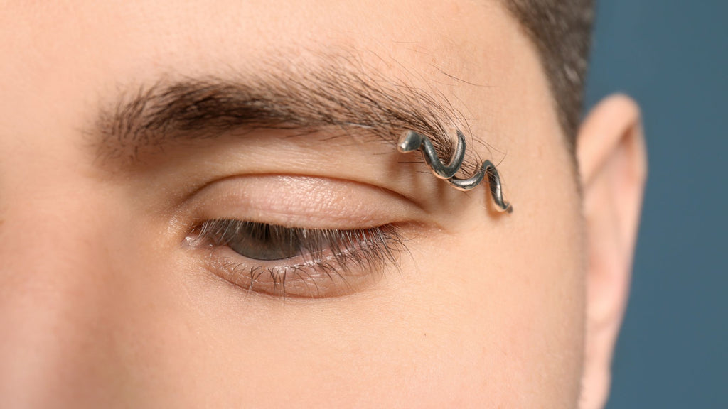 A man's eyebrow with a metal ring through it.