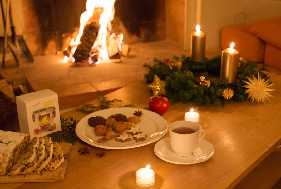 暖炉の前のテーブルに並べられたクリスマスクッキーとクリスマススペシャルブレンド