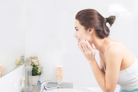 鏡をみる洗顔中の女性