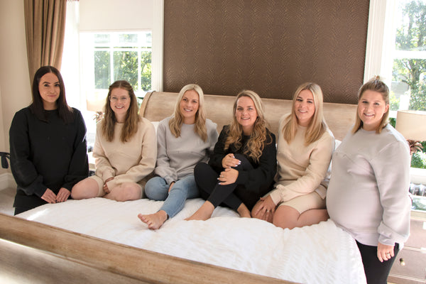 Women on a bed wearing maternity and nursing jumpers