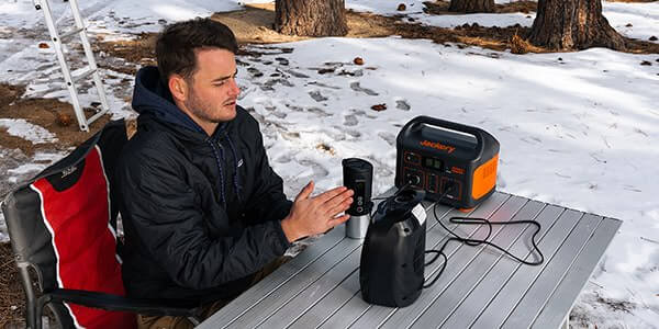 Jackery Explorer 550 Portable Power Station Drone View Showing A Man Sitting Outside On A Snowy Outdoor