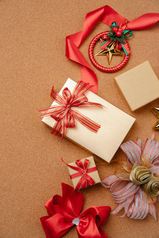There are multiple ways to add gift wrap ribbon to christmas presents, including the traditional 4-way wrap, an envelope wrap, a huge bow, or as a candy cane holder