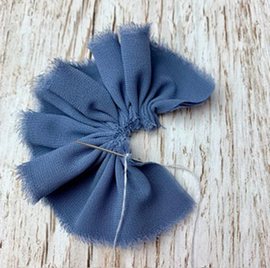 Step three of how to make a ribbon gathered flower DIY piece showing blue ribbon