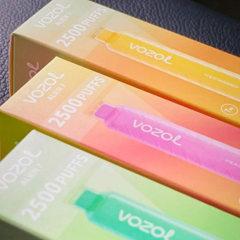 three boxes of vozol disposable vapes with green, pink and orange colours
