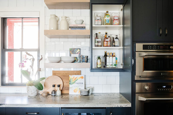 A beautifully organized kitchen countertop with a cabinet open to show spices organized