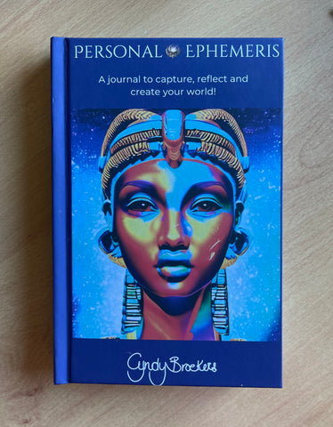 book titled Personal Ephemeris - A journal to capture, reflect and create your world! by Cyndy Broekers with an image of an Egyptian style priestess; focal colour Navy blue and cyan with orange