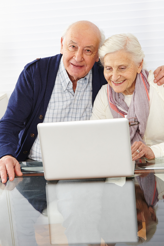 Elderly couple at their laptop