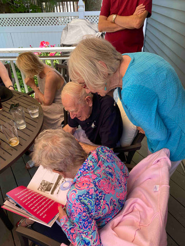 Bob and Barb going through their book with their family standing behind them