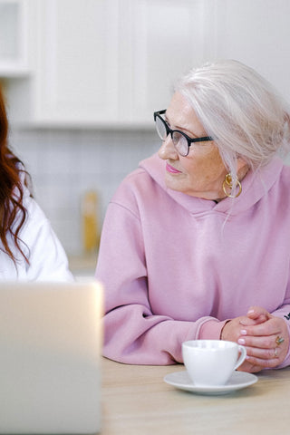 Elderly lady speaking with someone over coffee