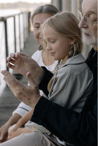 Grandpa telling a story to his granddaughter, using hand gestures