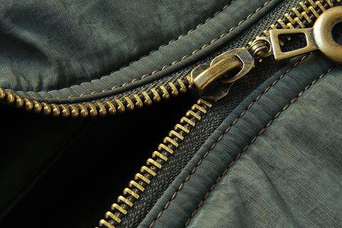 a brass zip on a raincoat