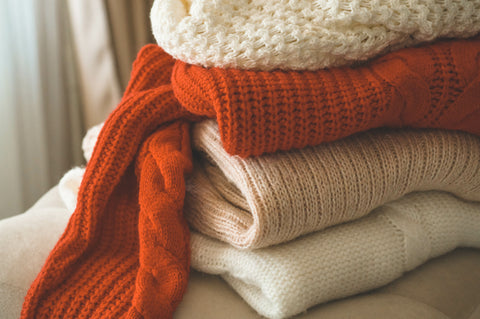 a pile of cosy woolen sweaters