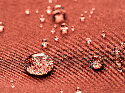 water droplets on rust colored waterproof fabric