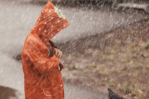 a child wearing a raincoat in heavy rain