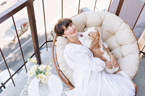 a woman in a white dress cuddling a beagle dog