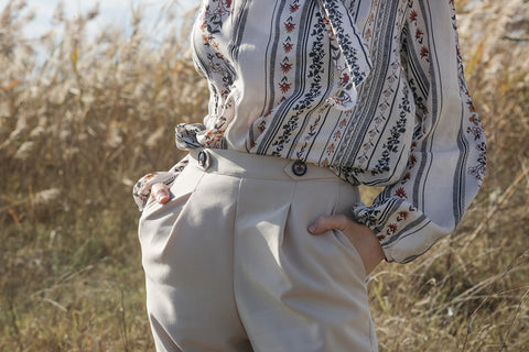 a close up of the waistband on a pair of smart pleated pants