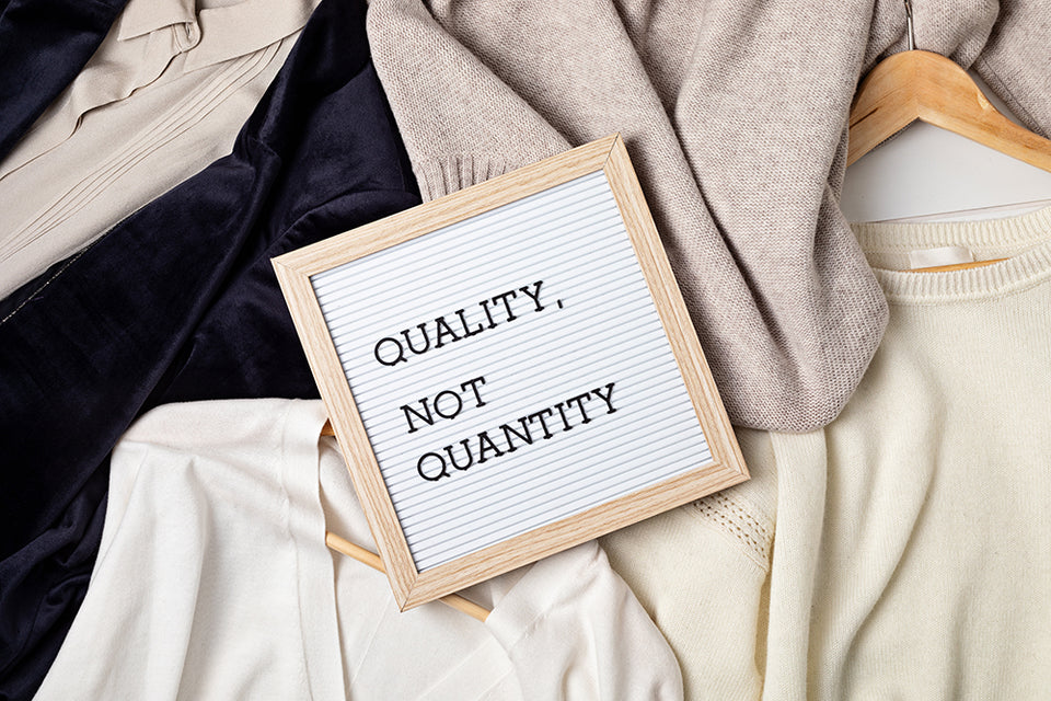  the mission statement ‘Quality, Not Quantity’ placed on top of a pile of sweaters and clothing