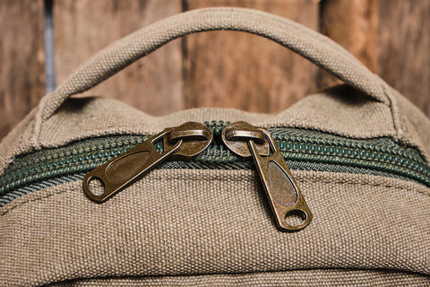 the top view of a brown material backpack with a zip