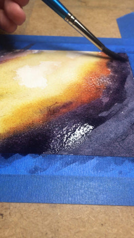 closeup image of watercolor paint being applied to a nebula painting