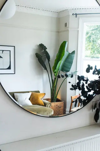 Miroir positionné pour augmenter la sensation de lumière naturelle dans un salon.