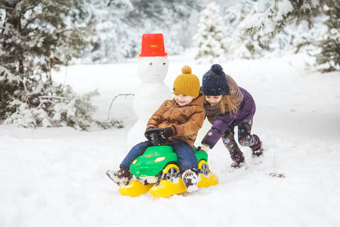 Kinder-Schneemann-Schlittenfahren