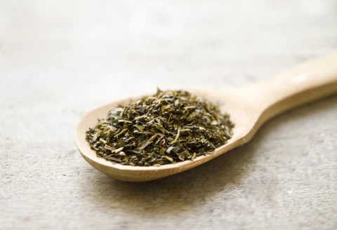Zielona herbata na drewnianej łyżce