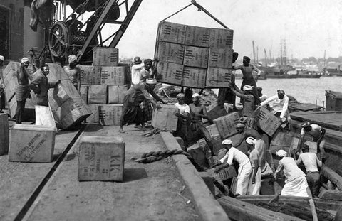 Loading chests of tea onto boats by Sri Lankans