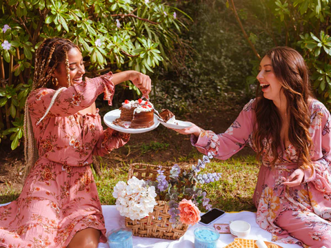 A moment of sharing a cake between two women