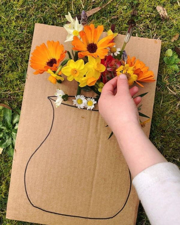 Flowers glued onto cardboard in a vase shape.