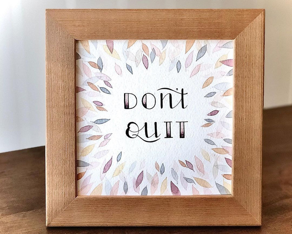 Watercolour hand lettering in a wooden frame.