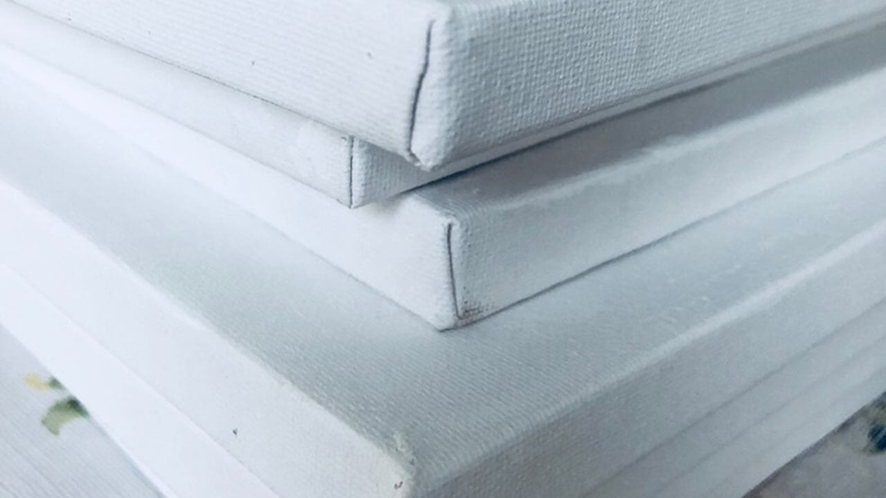 A stack of white canvases piled on one another.