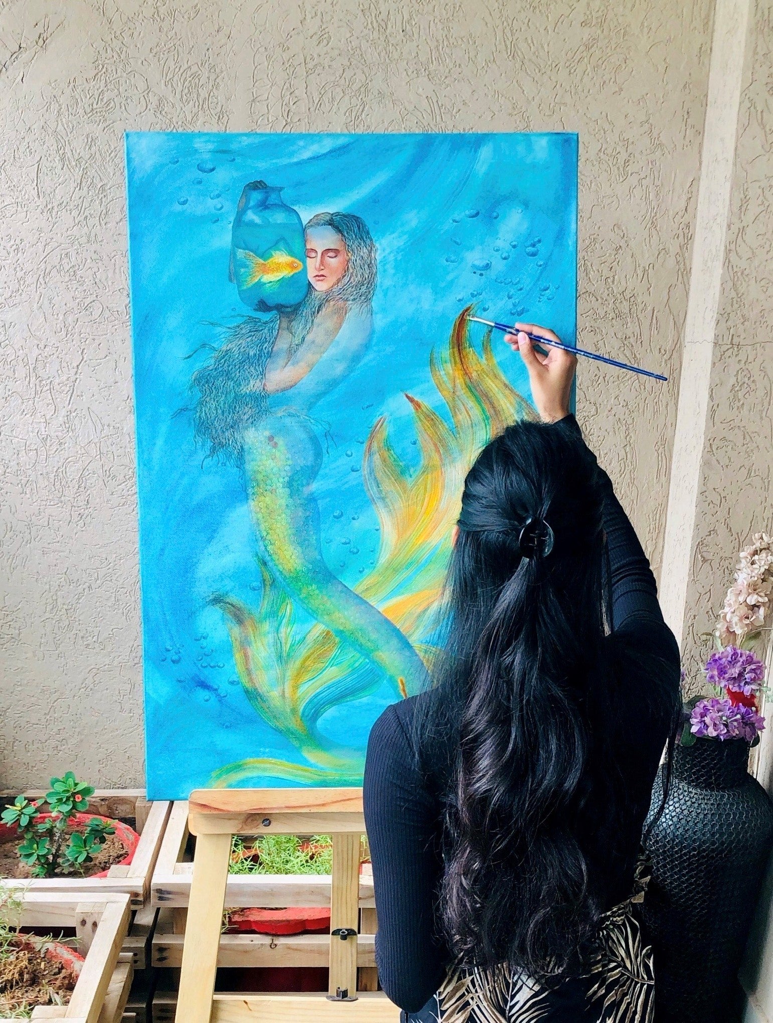 1. @Quinns_Arte painting a picture of a mermaid on a large canvas