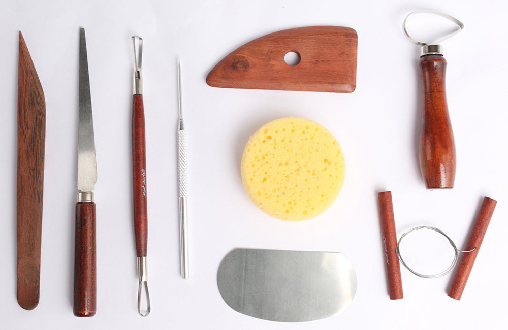 Flat lay image of various air dry clay tools on a white surface.