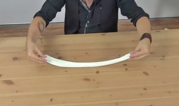 Man holding homemade glow in the dark slime on a wooden table.