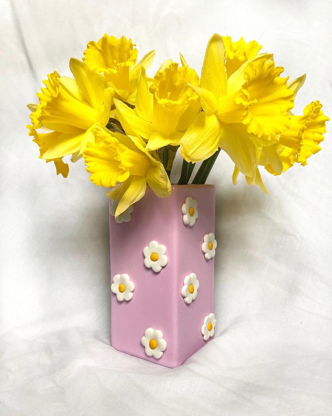 Lilac vase with polymer clay 3D daisies and daffodils inside the vase.