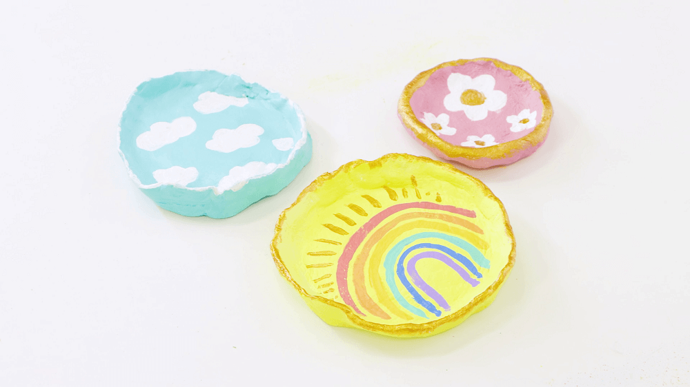 Three colourful trinket tray dishes made from clay each with a different design.