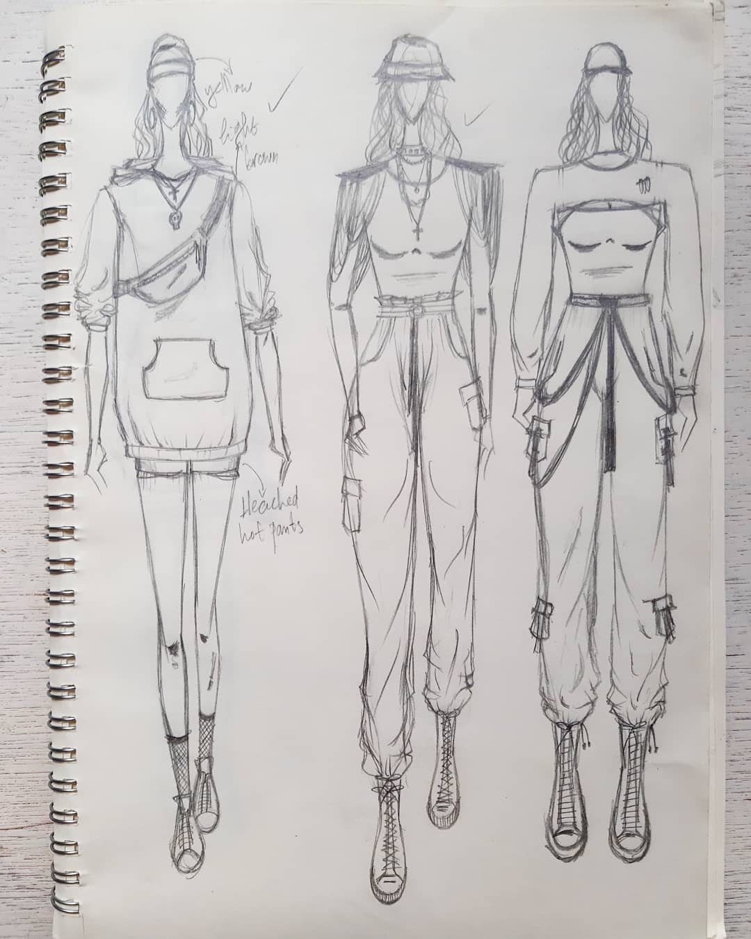 11. Three trendy outfits drawn in a fashion illustration style in a sketchbook.