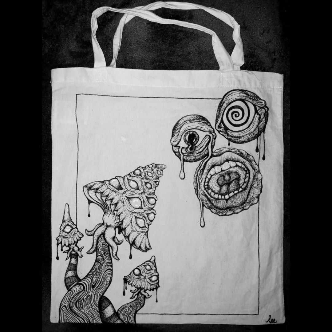 Surrealist painted tote bag painted with black fabric paint of a trippy mushroom and dripping eyes.