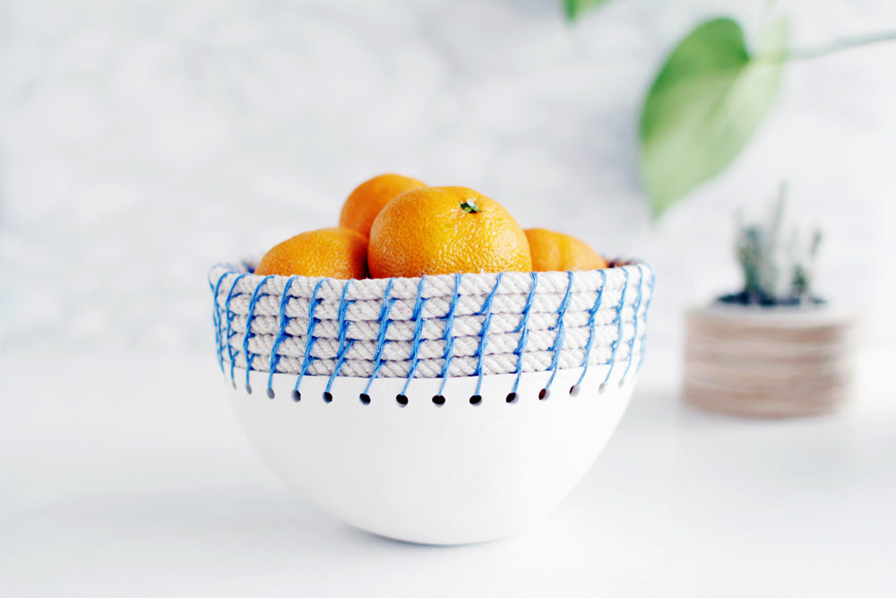 Bowl made from clay with oranges inside.